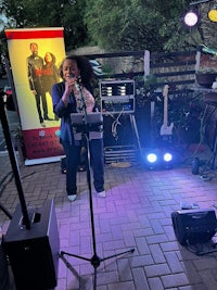a woman is playing a saxophone in front of a group of people
