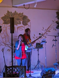 a group of people singing on stage in front of a wall