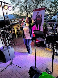 a woman singing on stage in front of a microphone