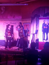 a man and a woman on stage at a bar
