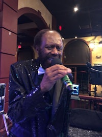 a man in a suit singing into a microphone