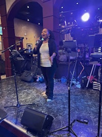 a woman singing on stage in front of a microphone