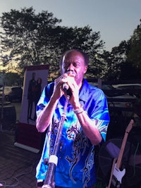 a man in a blue shirt singing into a microphone